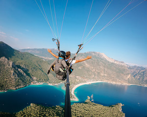 Paraglider flying above Oludeniz beach in Fethiye- Turkey during sunset a popolar paragliding spot 