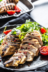 Chicken breast grilled with spices peper salt tomatoes and arugula