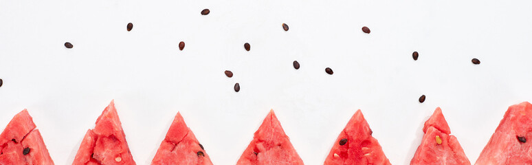panoramic shot of fresh watermelon slices and seeds on white background