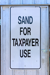 Sign saying sand for taxpayer use on a building
