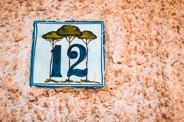 number 12 door sign on orange facadenumber 12 door sign on orange facade