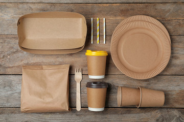 Flat lay composition with new paper dishware on wooden background. Eco life