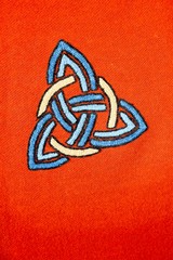 Interlaced triquetra symbol on a red blanket