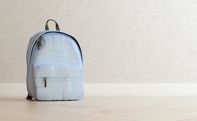 Realistic baby blue backpack on the wooden floor and light beige wall in the background, close up,...