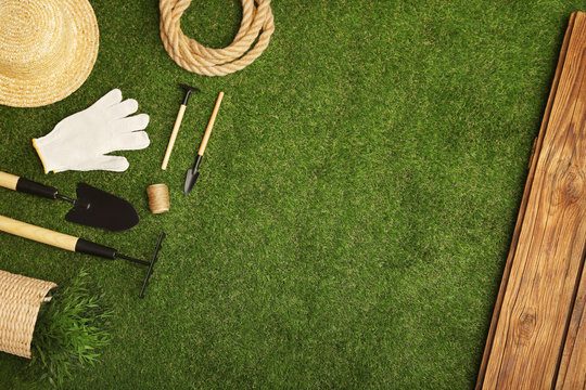 Set of gardening tools on green grass, flat lay. Space for text