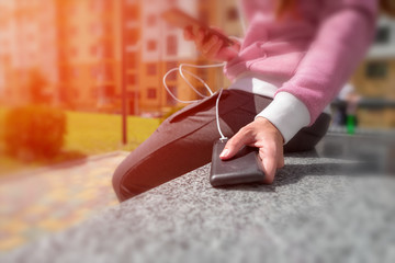woman hands holding black smartphone charging battery from external power bank