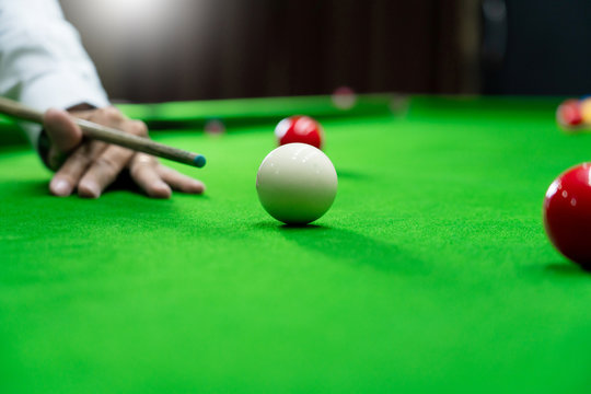 Game snooker billiards or opening frame player ready for the ball shot, athlete man kick cue on the green table in bar.