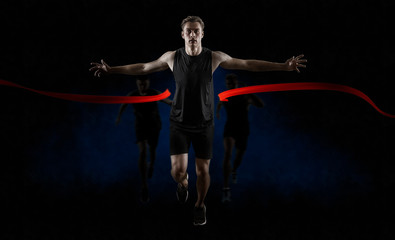 Runner wins by crossing the finish line on dark background