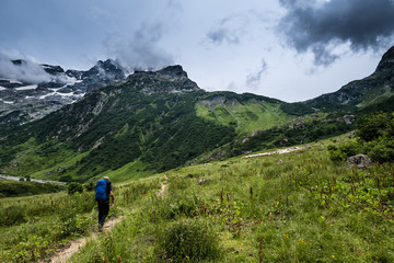 Fototapeta na wymiar Senior backpacker walking toward the Vallonpierre hut, a very nice refuge in the Ecrins National Park, French Alps