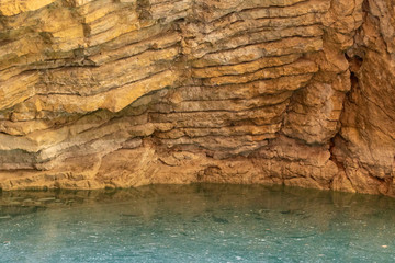 Karst lake in a mountain cave. Sulfurous lake. Beautiful natural texture and turquoise background of the lake combined with gold stone.