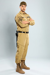 Male security guard in uniform on grey background