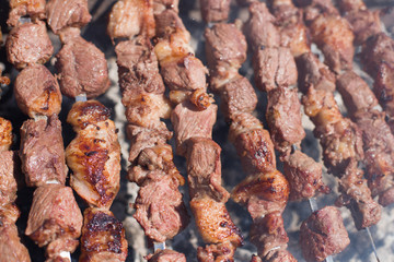 The texture of roasted meat. Appetizing cuts of meat on skewers. Grilled lamb, very tasty food. Kebab background.