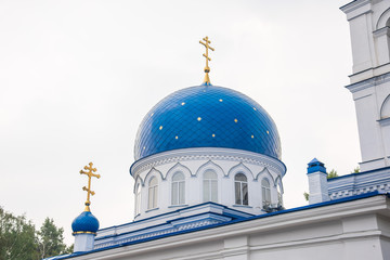 The roof of the Christian Church is made of white stone with blue domes with stars and gold crosses. Holy Trinity Church in Tomsk, Russia.