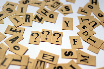 Closeup shot of a lot of small papers with Question marks and letters
