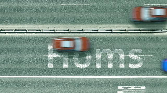 Aerial top down view of the road with cars revealing Homs caption. Car travel in Syria conceptual clip