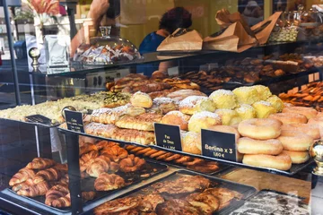 Foto op Plexiglas Display window of a bakery and pastry shop with assortment of different kinds of freshly baked artisan food. Authentic urban atmosphere © olindana