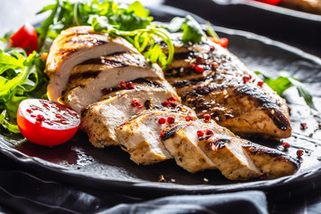 Chicken breast grilled with spices peper salt tomatoes and arugula