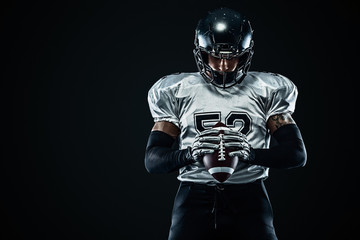 American football sportsman player in helmet on black background. Sport and motivation. Team sports.