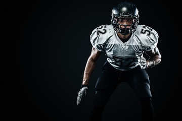 Fototapeta na wymiar American football sportsman player in helmet on black background. Sport and motivation. Team sports.