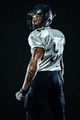 American football sportsman player in helmet on black background. Sport and motivation. Team sports.