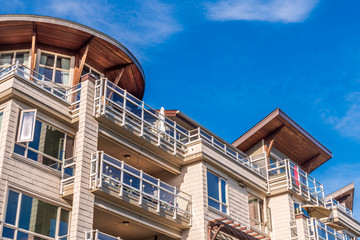 The top of an apartment building with nice windows.