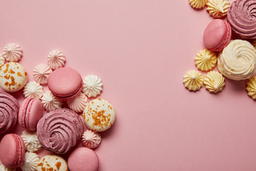 Fototapeta na wymiar Delicious sweet macaroons and colorful meringues on pink background