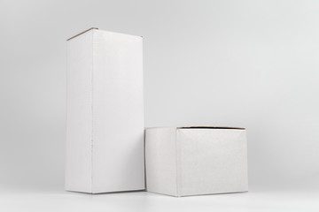 White two paper boxes - tall and fat lay on the white background in studio shot with clipping paht.