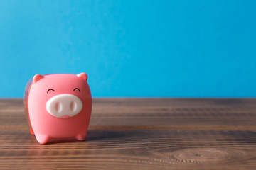 Little piggy Bank on the wooden table. Close up. The concept of saving money.