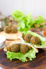 Nice vegetarian falafel in pita bread on wooden board.