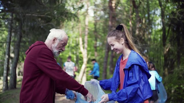 Group of fit people picking up litter in nature, a plogging concept.