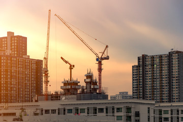 Fototapeta premium Bangkok, Thailand : July 16, 2019 - Crane and construction site working on building complex at sunset, developing city concept