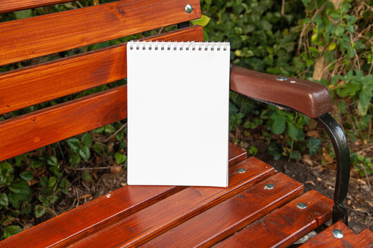Copy Space Spiralblock Zeichenblock Writing pad steht angeleht auf einer Gartenbank