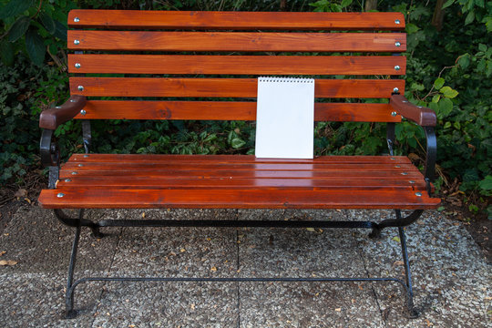 Copy Space Spiralblock steht auf einer Gartenbank angelehnt