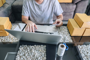 Small business parcel for shipment to client, Young man received online shopping parcel opening boxes and buying items by credit card, online marketing on purchase order package product