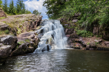 Beautiful little Arbinje waterfall on Old mountain and wet, red rocks