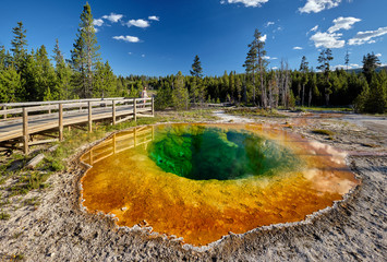 Tourists with backpack at hot thermal spring Morning Glory Pool in Yellowstone National Park, Wyoming, USA