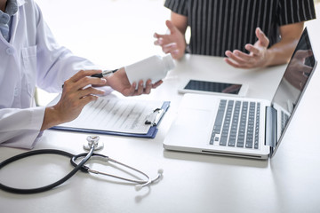 Doctor consulting patient discussing something symptom of disease and recommend treatment methods, presenting results on report and prescription, Medicine and health care concept