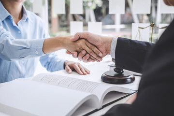 Handshake after good cooperation, Businesswoman Shaking hands with Professional male lawyer after discussing good deal of contract in courtroom, Concepts of law, Judge gavel with scales of justice