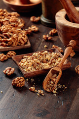 Walnuts in a wooden dish on an old wooden table.