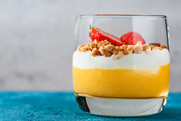 Frontal view of mango parfait with mussels and strawberries close-up