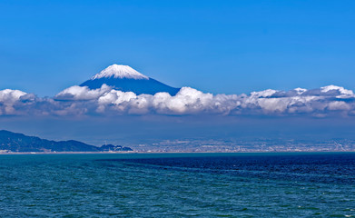 Sea approach to Shimizu, Japan with the snow capped peak of the iconic Mt. Fuji gleaming above low clouds