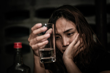 Asian woman drink vodka alone at home on night time,Thailand people,Stress woman drunk concept
