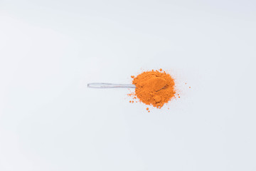 Curry powder in the spoon isolated on white background
