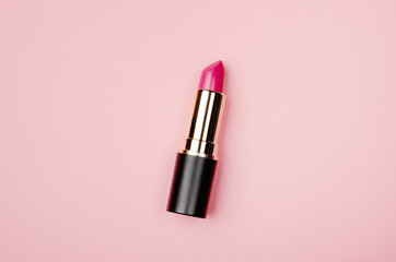 Pink lipstick tube, lip gloss top view. Beauty industry concept. Glamorous makeup accessory close...