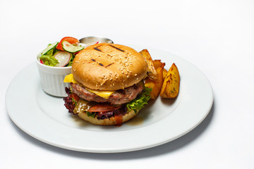 burger with beef cutlet and baked potatoes and vegetable salad