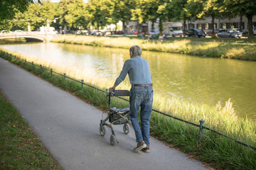 Senior - Spaziergang in Jeans und Rollator