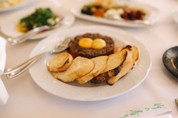 Beef tartare with eggs yolks and toasts. Banquet concept