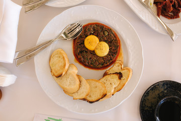 Beef tartare with eggs yolks and toasts. Banquet concept. top view