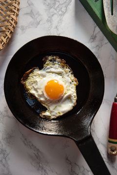 One sunny side up egg in a cast iron frying pan