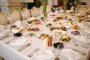 Table with mixed food. Banquet in restaurant, table setting. Differend meals for the guests. Fresh food